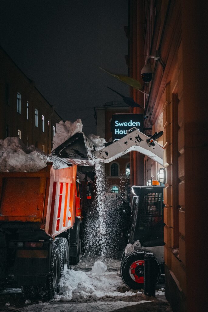 Bilden visar en motviktstruck som lastar en lastbil. Det krävs truckförarutbildning för att framföra en truck krävs truckkort