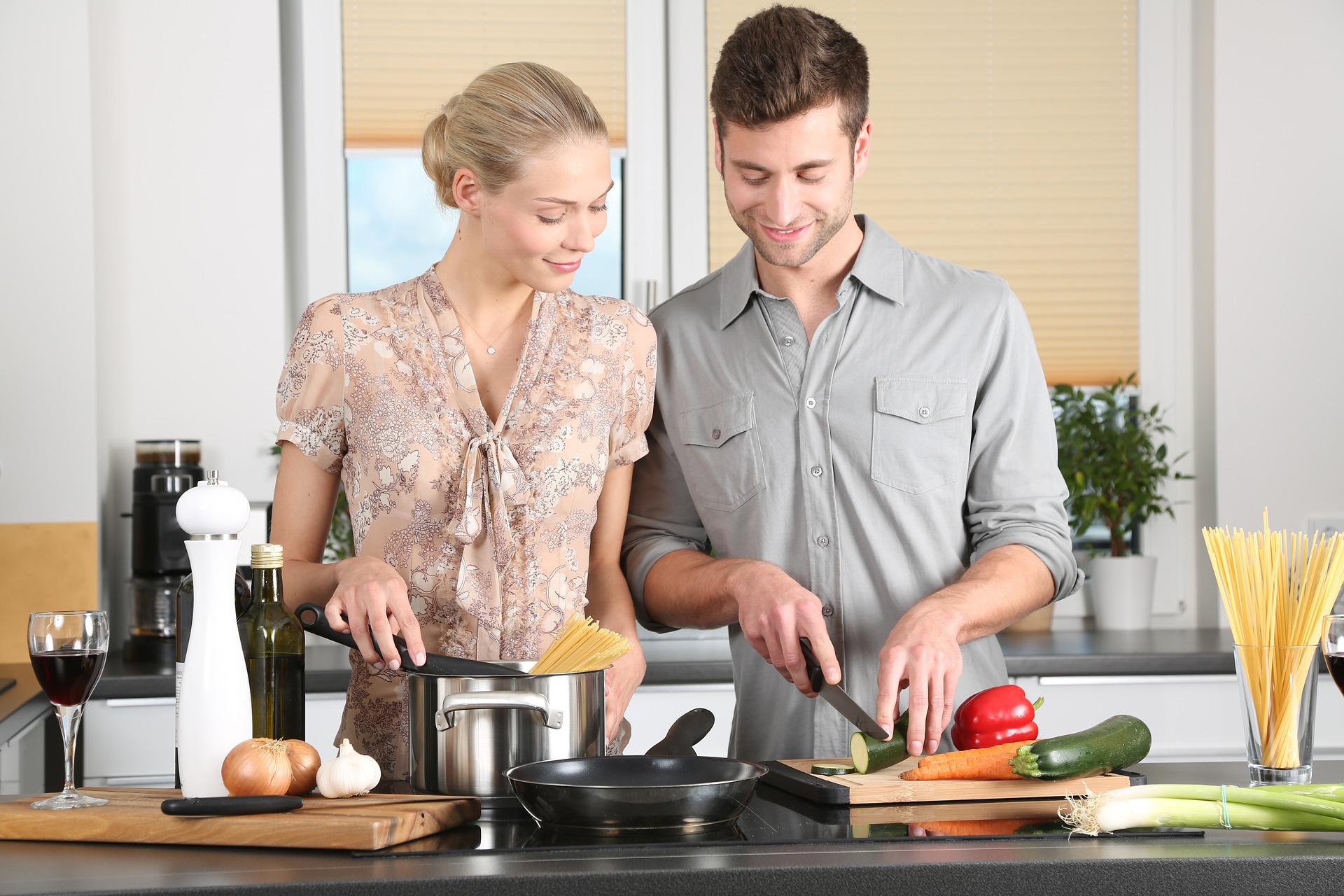 Bilden visar ett par i köket som lagar mat. Med billiga råvaror och rester kan du enkelt skapa nya maträtter.